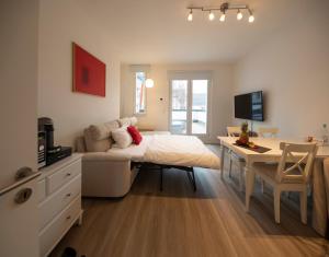a bedroom with a bed and a table and a desk at Apartment direkt am Hafen - mit Terrasse und UHD TV in Dortmund