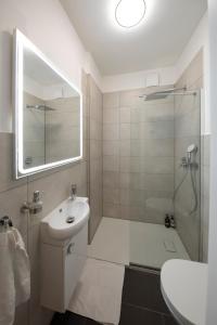 a bathroom with a sink and a shower with a mirror at Apartment direkt am Hafen - mit Terrasse und UHD TV in Dortmund
