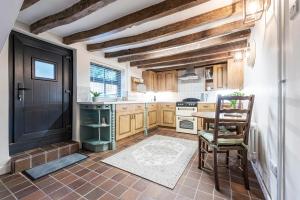 una cocina con armarios de madera y una puerta negra en Bieldside Cottage en Ollerton