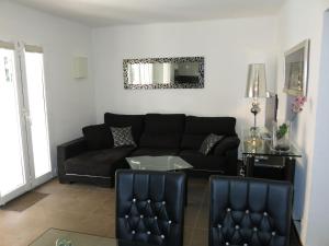 a living room with a black couch and a mirror at Holiday Home Ingeborg by Interhome in Vilafortuny +14 photos