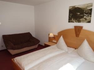 a bedroom with a bed and a chair at Apartment Altes Zollhaus-3 by Interhome in Nauders +39 photos