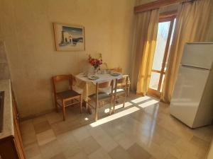 a kitchen with a table with chairs and a refrigerator at Hotel Elman in Palaiochóra