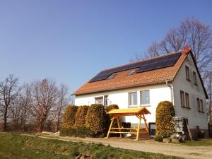 Treben的住宿－Ferienwohnung Schöne Aussicht，屋顶上设有太阳能电池板的白色房子