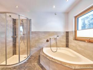 レンゲンフェルトにあるApartment Agnesn-2 by Interhomeの浴槽とガラスのシャワー付きのバスルーム