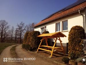 a wooden picnic table in front of a house at Ferienwohnung Schöne Aussicht in Treben