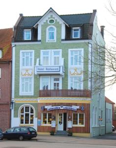 クックスハーフェンにあるHotel Münchner Löwenbräuの館内レストランを読む看板のある建物