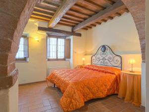 een slaapkamer met een bed met een oranje sprei bij Apartment Michelangelo by Interhome in Piecorto