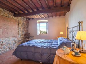 een slaapkamer met een blauw bed en een tafel bij Apartment Leonardo by Interhome in Piecorto