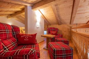 a living room with two red chairs and a table at Kaser Premium Chalet am Berg in Neustift im Stubaital
