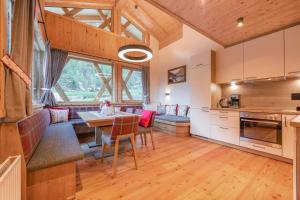 a kitchen and living room with a table and chairs at Kaser Premium Chalet am Berg in Neustift im Stubaital
