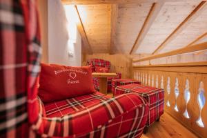 a living room with two red chairs in a cabin at Kaser Premium Chalet am Berg in Neustift im Stubaital