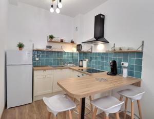 cocina con mesa de madera y nevera blanca en Superbe appartement, en Marsella
