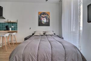 a bed in a bedroom with a painting of a dog at Superbe appartement in Marseille