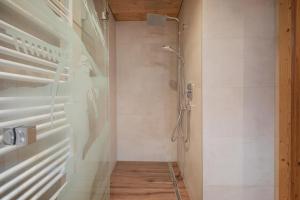 a bathroom with a shower with a glass door at Kaser Premium Chalet am Berg in Neustift im Stubaital +13 photos