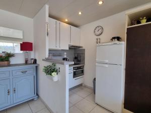 cocina con armarios blancos y nevera blanca en Apartment De la Plage-1 by Interhome, en Cavalaire-sur-Mer