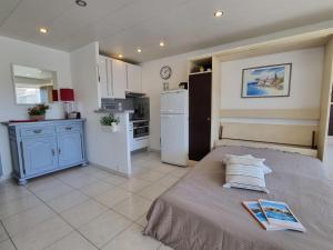 a bedroom with a large bed and a kitchen at Apartment De la Plage-1 by Interhome in Cavalaire-sur-Mer