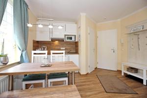 a kitchen and living room with a wooden table and a dining room at Ostseewelle Wohnung 10 in Kühlungsborn +14 photos