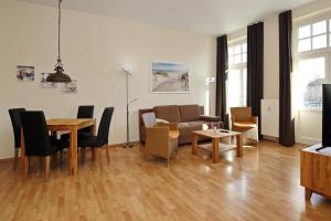 ein Wohnzimmer mit einem Tisch und einem Sofa in der Unterkunft Haus am Park Wohnung 28 in Kühlungsborn