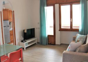 ein Wohnzimmer mit einem Sofa, einem Tisch und einem TV in der Unterkunft Casa Luce Sabaudia in Sabaudia