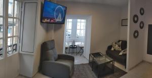 a living room with a couch and a tv on the wall at Casa Concha in Muros