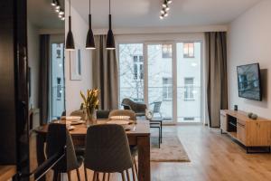 a dining room and living room with a table and chairs at Złote Apartamenty 36 in Legnica