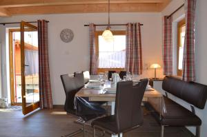 a dining room with a wooden table and chairs at Feriendorf Via Claudia Haus 58 Alpenliebe in Lechbruck