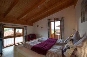 a bedroom with a bed and a large window at Feriendorf Via Claudia Haus 58 Alpenliebe in Lechbruck