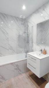 a white bathroom with a shower and a sink at Złote Apartamenty 36 in Legnica