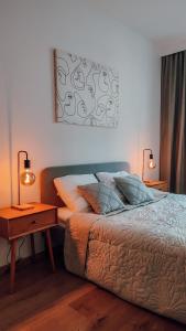 1 dormitorio con 1 cama con 2 lámparas y 1 mesa en Złote Apartamenty 36, en Legnica