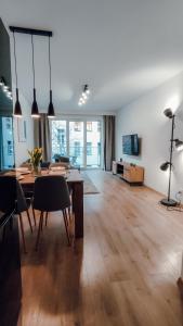 sala de estar con mesa de madera y comedor en Złote Apartamenty 36, en Legnica