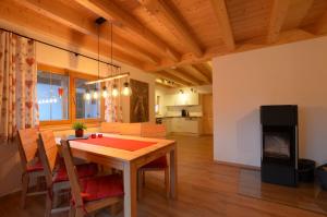 a kitchen and dining room with a table and a fireplace at Feriendorf Via Claudia Haus 78 Platzhirsch in Lechbruck