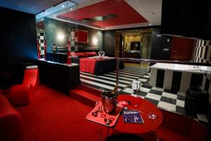 a living room with a bed and a red table at Motel Venus Pontevedra in Poio