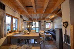 a kitchen and living room with a wooden ceiling at Feriendorf Via Claudia Haus 45 Claudia in Lechbruck