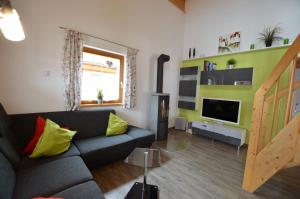 a living room with a couch and a television at Feriendorf Via Claudia Haus 42 Onkel Leo in Lechbruck