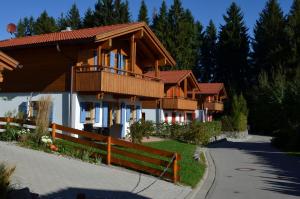 a house with a porch and a fence at Feriendorf Via Claudia Haus 62 Bernhard in Lechbruck