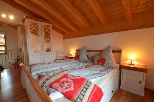 a large bed in a room with wooden ceilings at Feriendorf Via Claudia Haus 64 Berg- und Seetraum in Lechbruck
