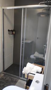 a bathroom with a glass shower with two chairs at Casa Concha in Muros +12 photos