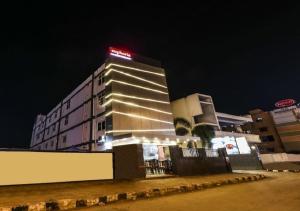 um edifício com um sinal em cima dele à noite em Euphoria Extended Stays - OMR IT Expressway Chennai em Chennai