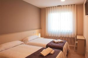 pokój hotelowy z dwoma łóżkami i oknem w obiekcie Hotel La Puerta de Arzúa w mieście Arzúa