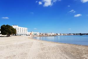 - une vue sur la plage, les bâtiments et l'eau dans l'établissement Appartamenti Via Tecchi, à Porto Cesareo