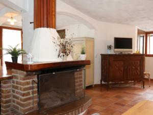 a living room with a fireplace and a tv at [Ghigo di Prali] Ampio Chalet tra le Alpi in Ghigo