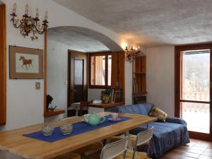 a living room with a table and a blue couch at [Ghigo di Prali] Ampio Chalet tra le Alpi in Ghigo