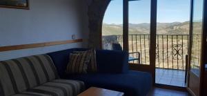 a living room with a blue couch and a balcony at Zapatera in Letur