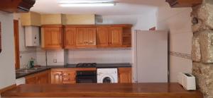 a kitchen with wooden cabinets and a white refrigerator at Zapatera in Letur