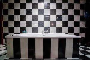 a bathroom with a white tile floor and a black and white tile floor at Motel Venus Pontevedra in Poio