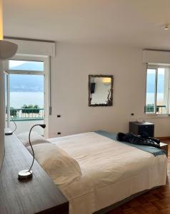 um quarto com uma cama grande e uma janela grande em Albergo Del Sole em Porto Valtravaglia