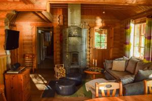 a living room with a fireplace in a log cabin at Lomalehto Cottages in Kiviapaja