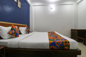 um quarto com uma cama com uma parede azul em FabExpress Royal Stays em Haridwar