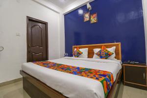 um quarto com uma cama grande e uma parede azul em FabExpress Royal Stays em Haridwar