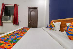 um quarto com uma cama com um edredão colorido em FabExpress Royal Stays em Haridwar